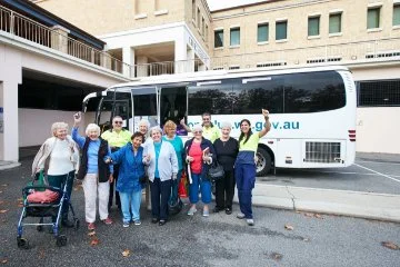 Photo of a community group in front of a bus