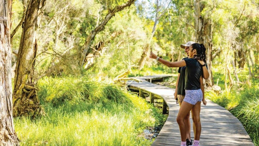 Photo of two people walking in a park