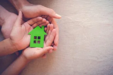 image of a green cardboard house held in hands