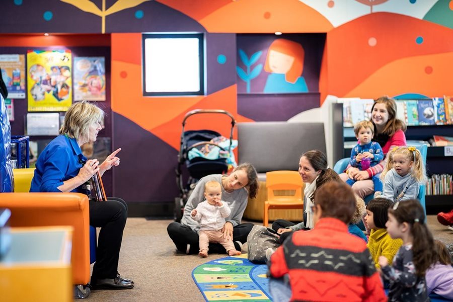 Babies engaged by a librarian at a library 