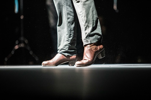 Man's legs, wearing jeans and brown boots