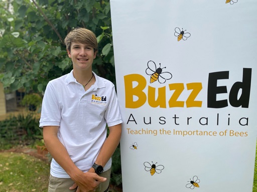 Young man standing in front of Buzz Ed Banner