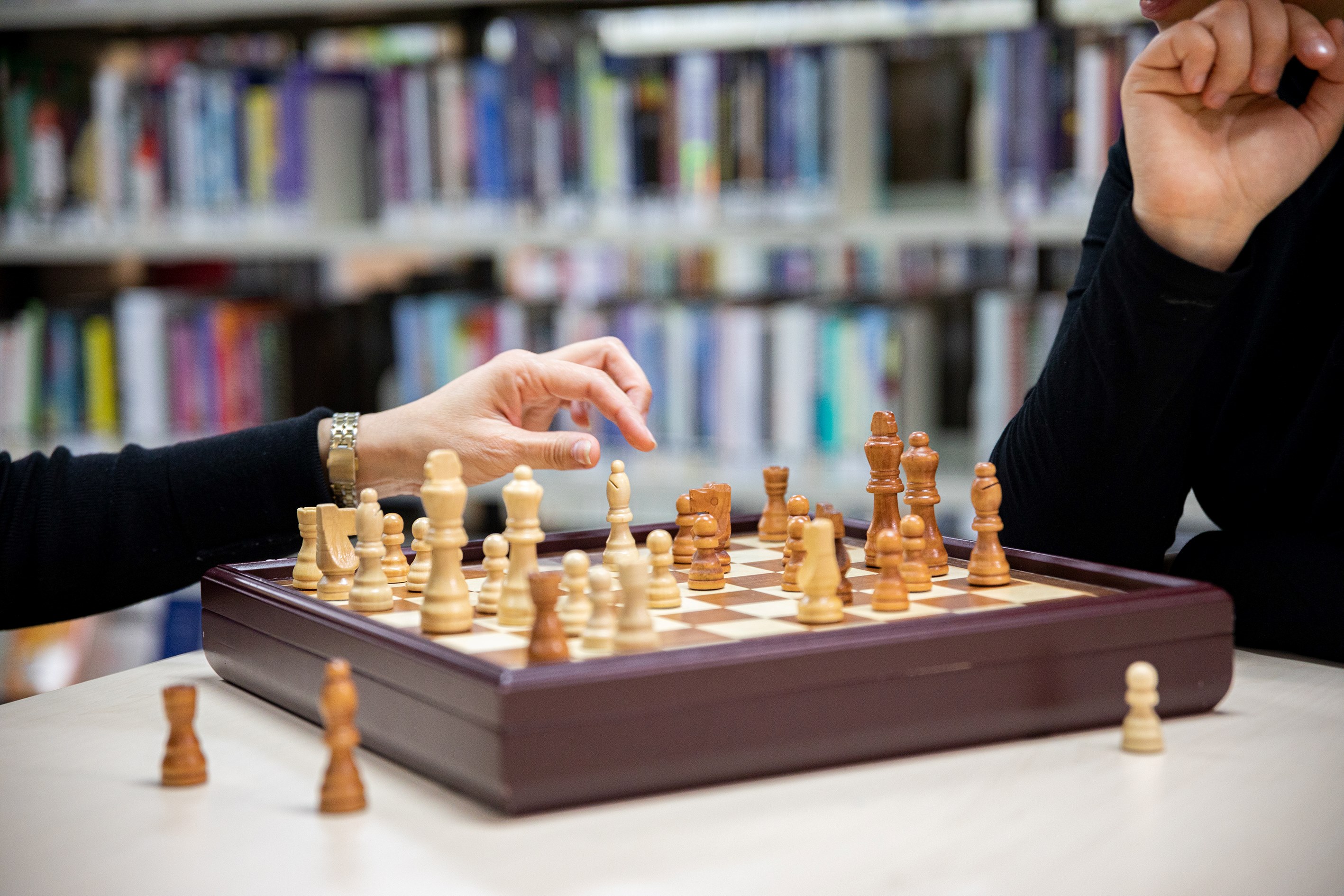 People playing chess in a library