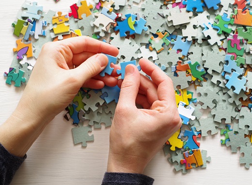 hands working on a jigsaw puzzle