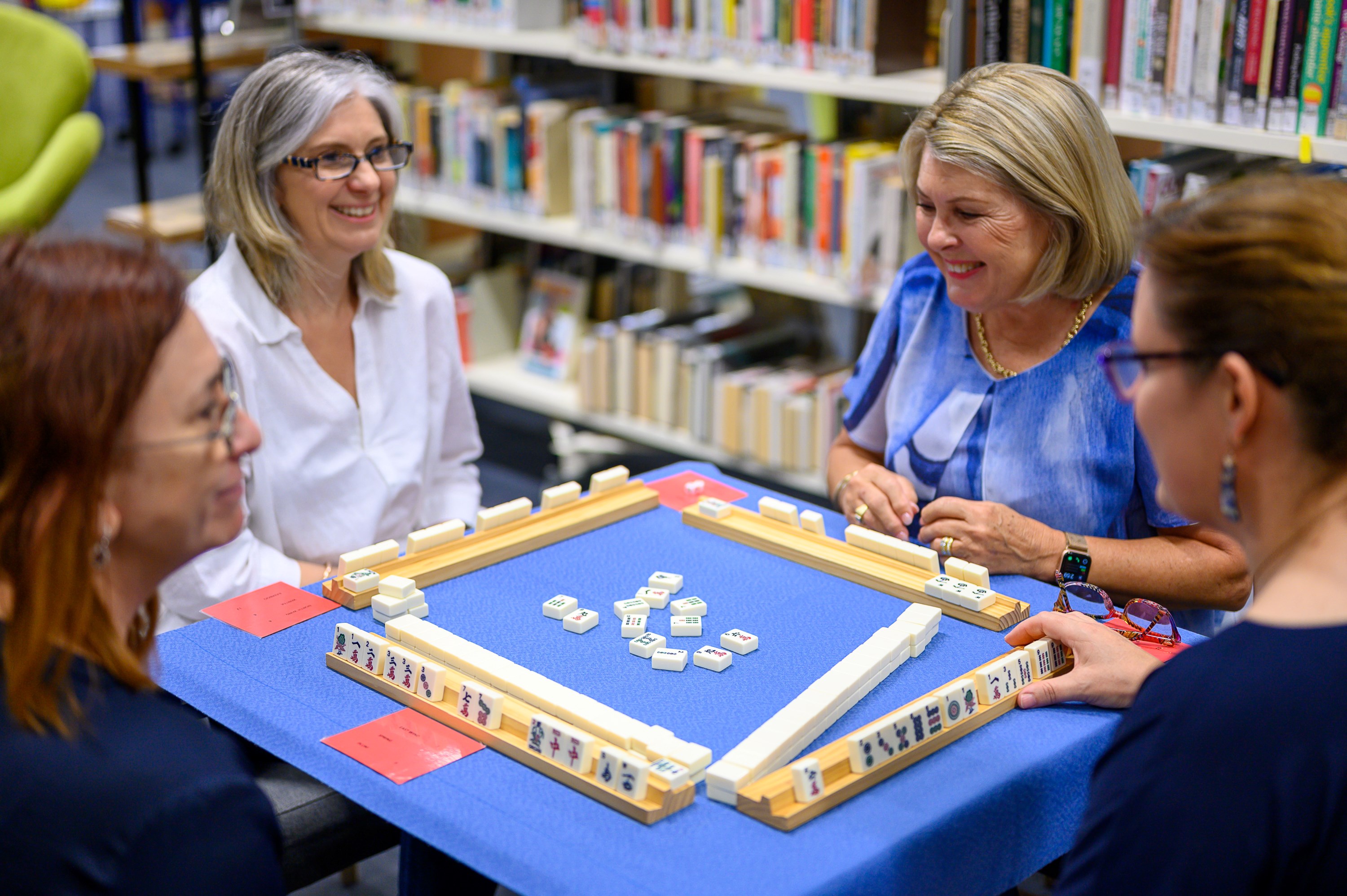 Four people playing a game of mah-jong