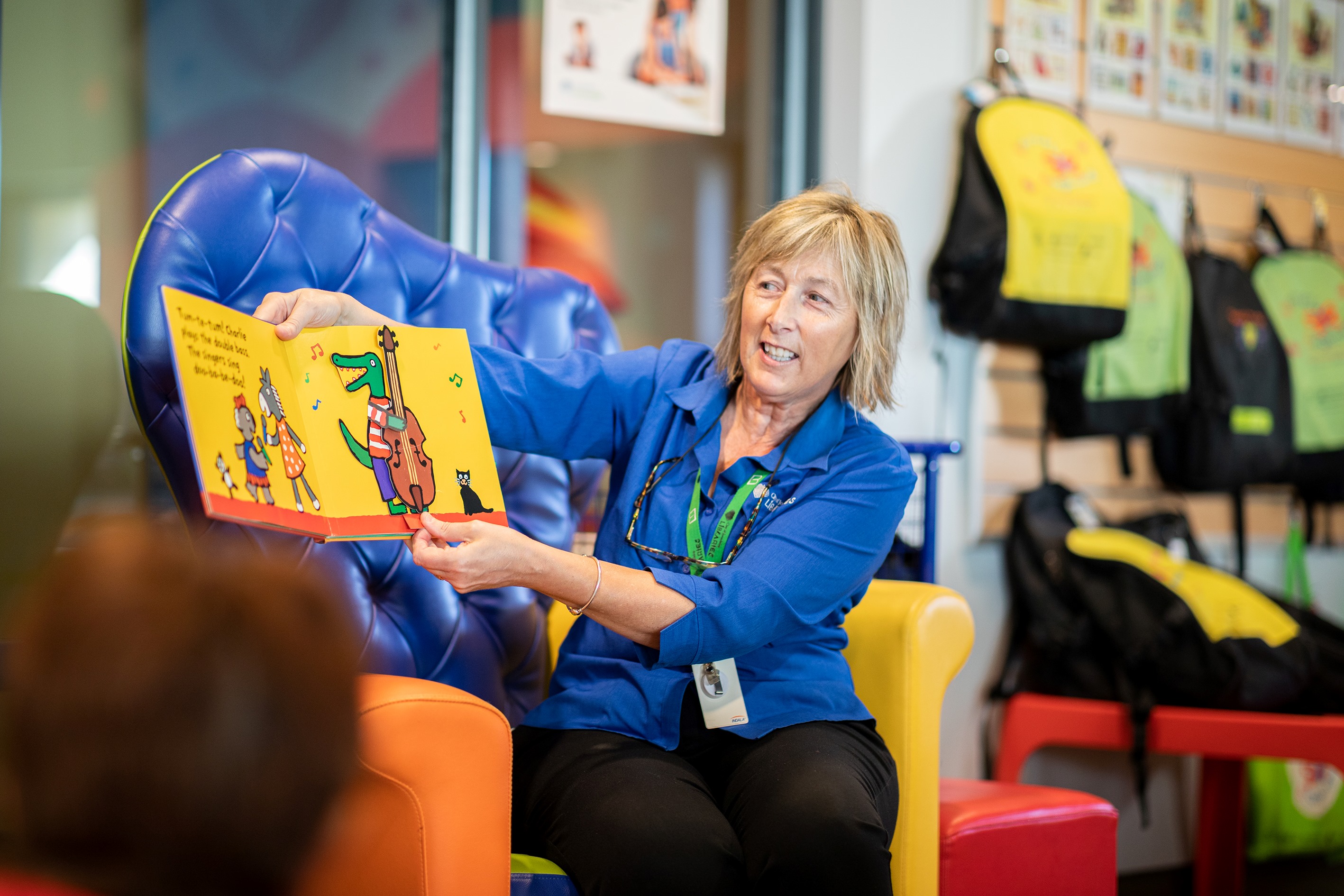 A librarian reading an early childhood book to a group