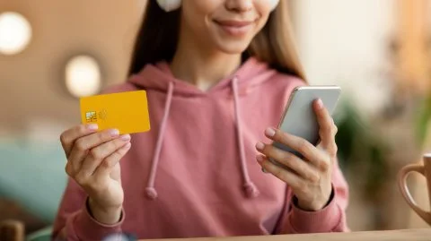 Girl with mobile phone and bank card