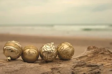 Gold christmas baubles sitting on a log