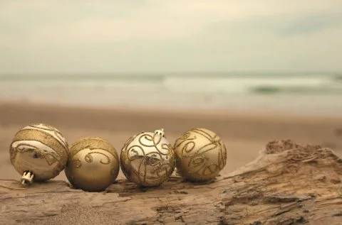 Gold christmas baubles sitting on a log